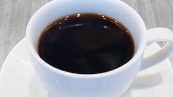 A white cup of coffee on a saucer.