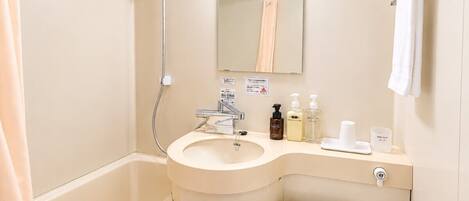 A bathroom with a sink, mirror, towel rack, shower, and toilet.