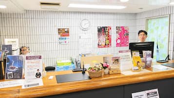 A reception desk with a clock, calendar, and various informational posters.