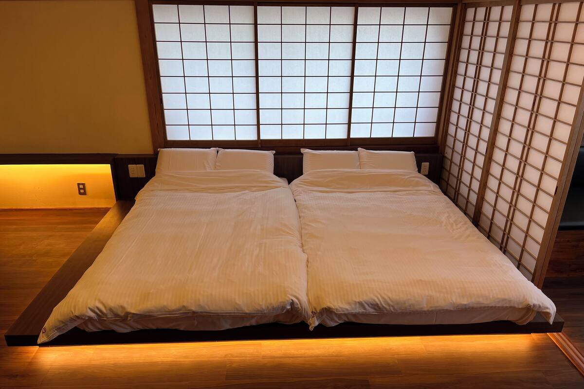 Una cama con estructura de madera y cabecera con diseño de cuadrícula.