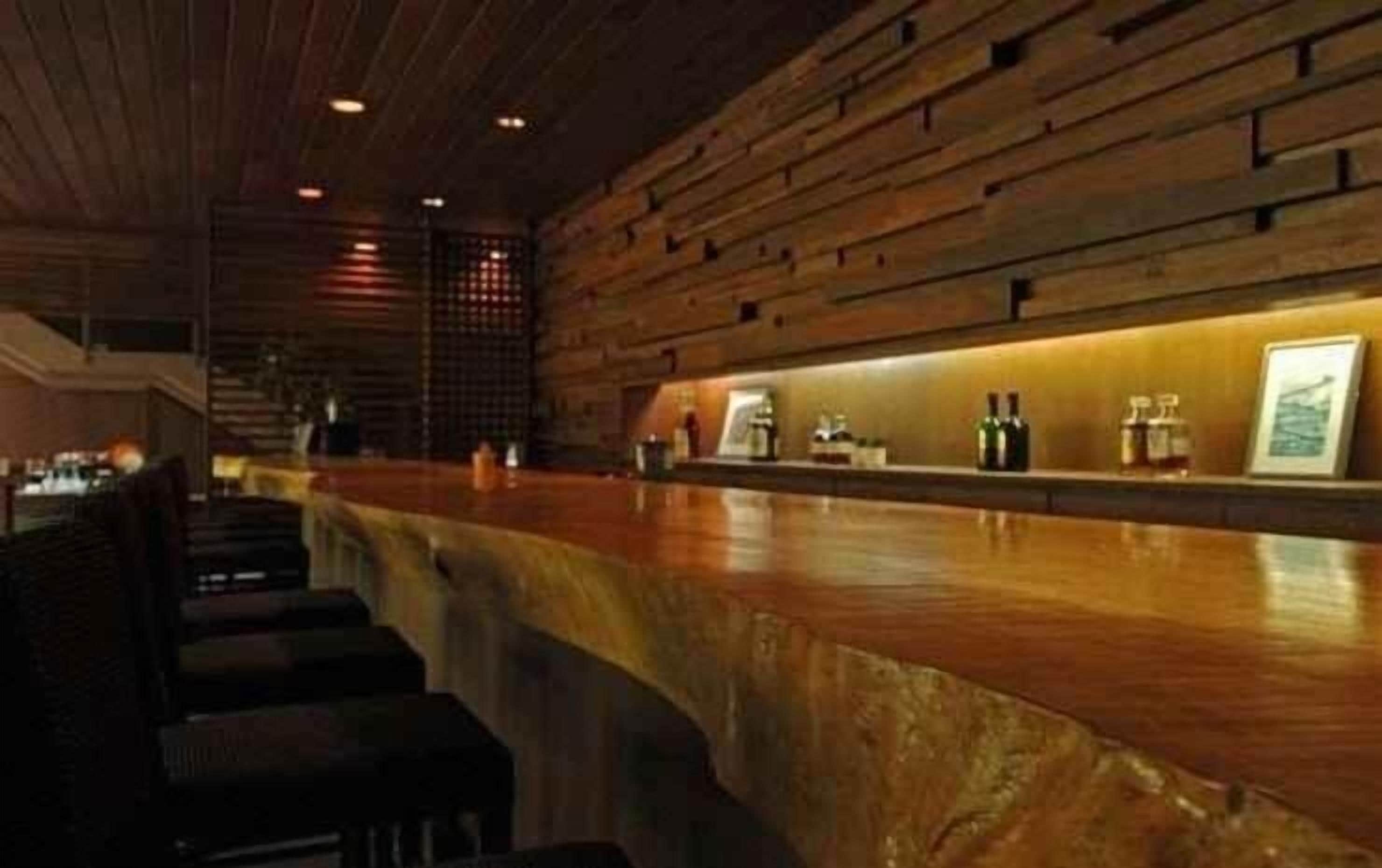 A bar area with a wooden counter and seating.