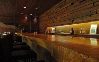 Una zona de bar con mostrador y asientos de madera.