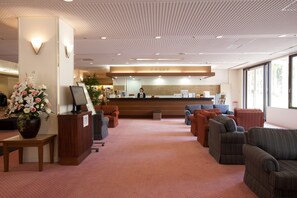 A reception area with a counter, seating, and a large window.