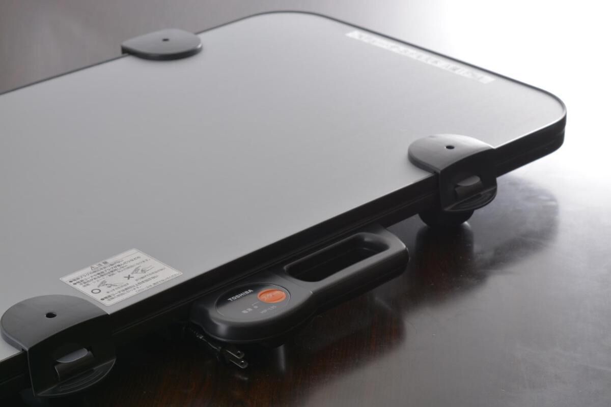 A Toshiba laptop with a sticker, a power button, and a USB port.