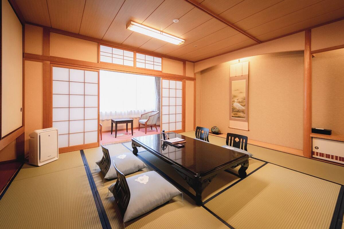 A traditional Japanese-style room with tatami flooring, a low table, and sliding doors.