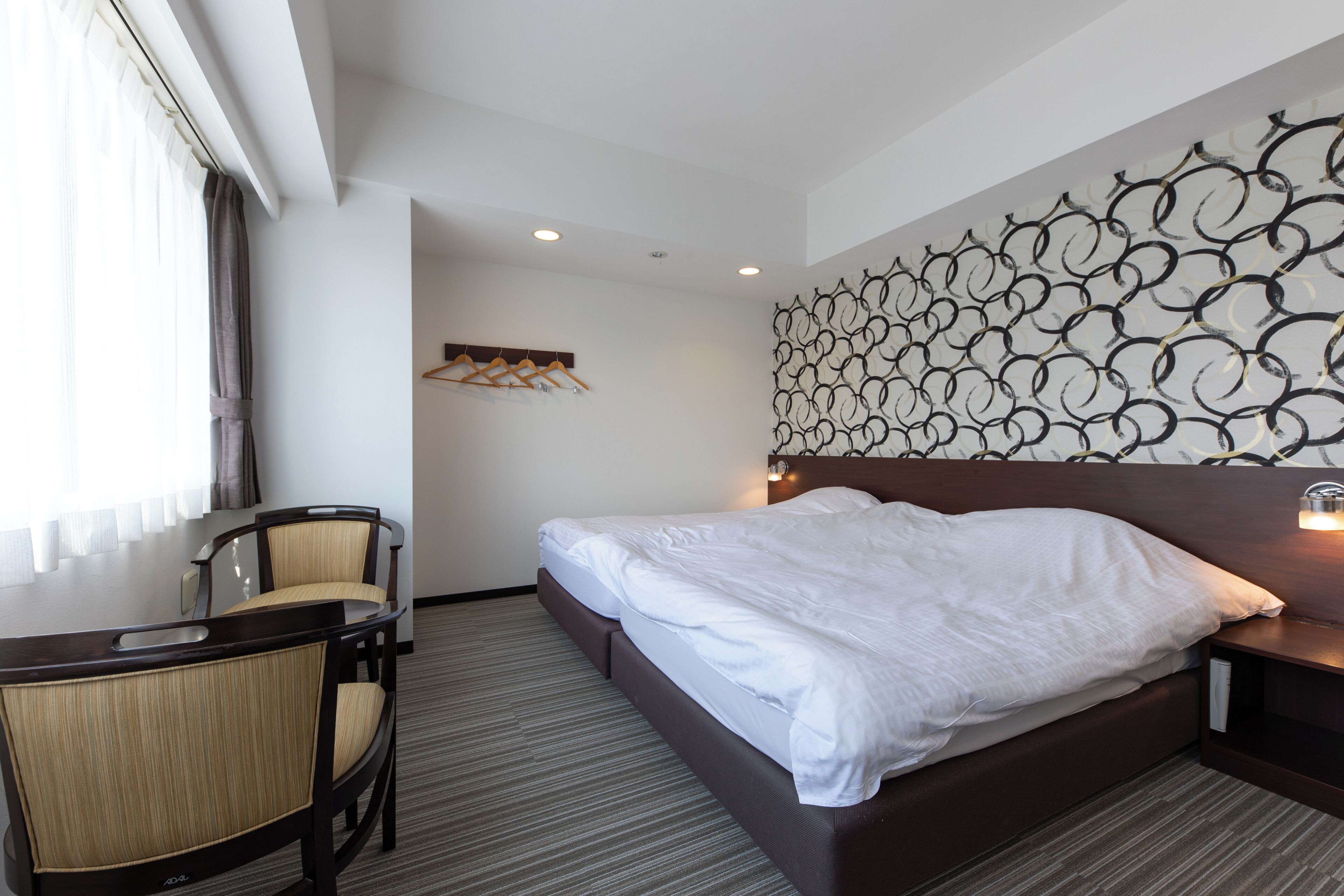 Una habitación de hotel con una cama, un escritorio y sillas.