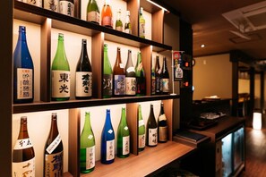 A shelf with various bottles of beverages, likely alcoholic, with labels in a non-Latin script, possibly Japanese. - Kajikaso (Yonezawa)