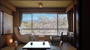 A traditional Japanese room with tatami flooring, a low table, and two chairs. - Kajikaso (Yonezawa)