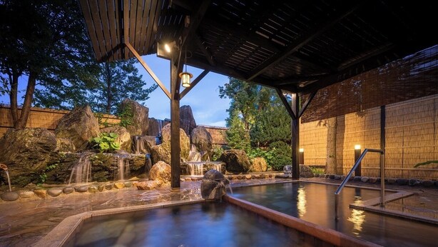 A hot spring area with a wooden deck, a stone pool, and a waterfall. - Kajikaso (Yonezawa)