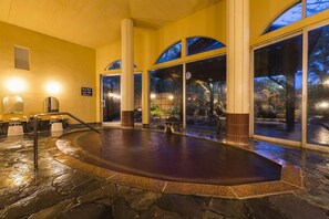 A stone-floored indoor pool area with a view of the outdoors through large windows. - Kajikaso (Yonezawa)