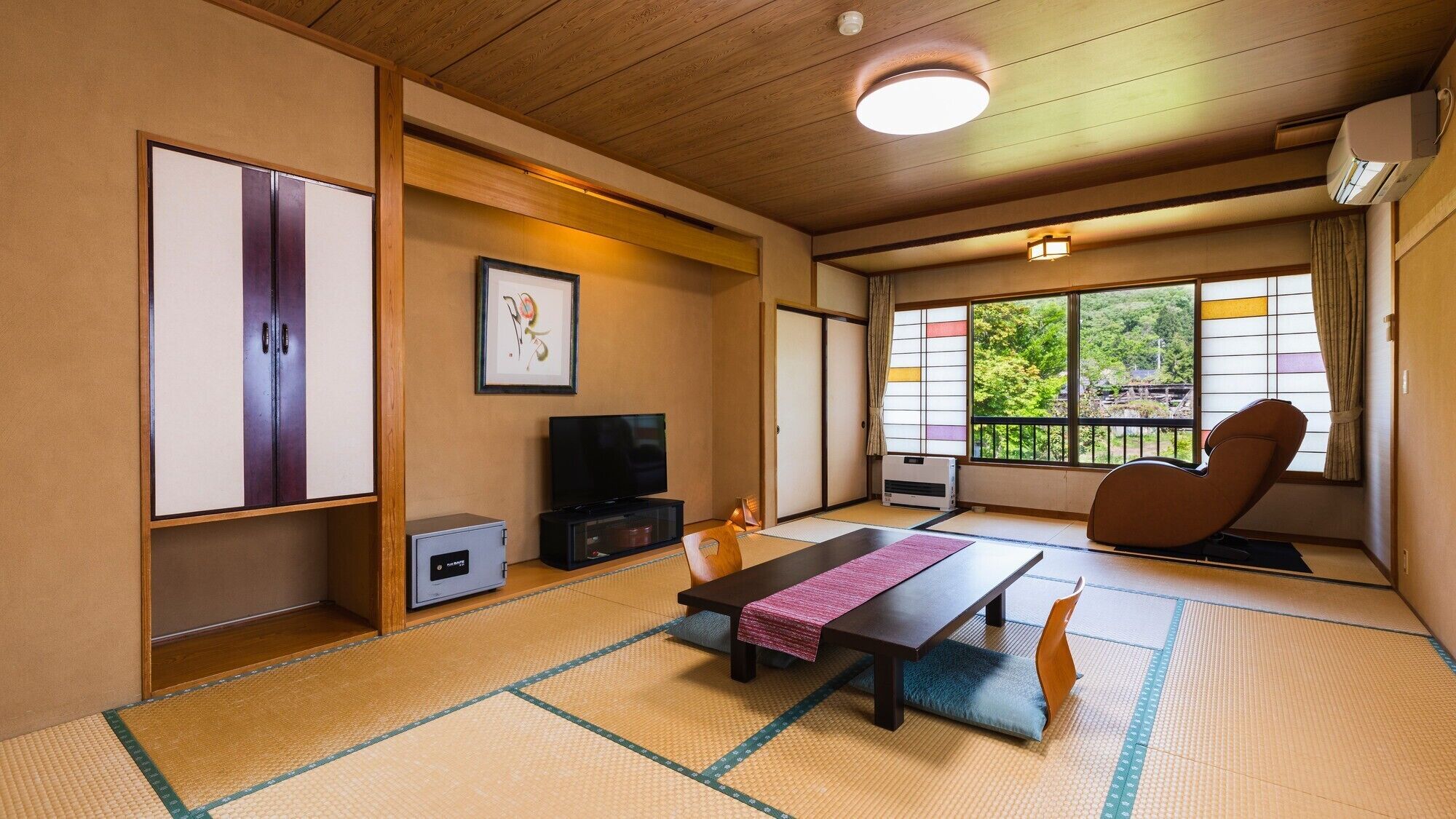 Perinteinen japanilainen huone, jossa on tatamimatto, televisio, futon-patja ja liukuovi, joka johtaa parvekkeelle, jolta on näkymä.