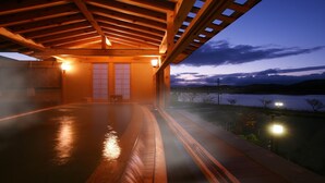A wooden deck with a view of a lake at dusk. - Hotel Shion (Morioka)