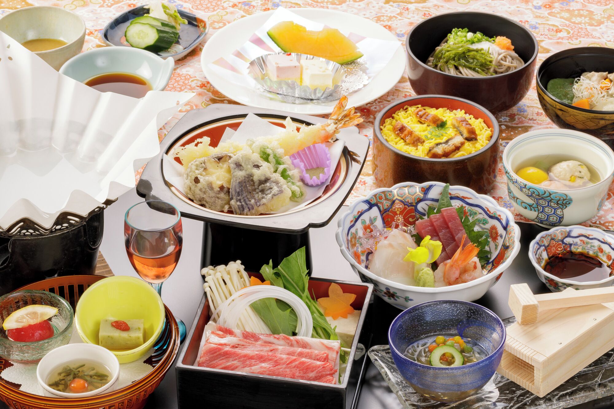 A variety of Japanese dishes and condiments arranged on a table, including sushi, sashimi, and pickled vegetables.