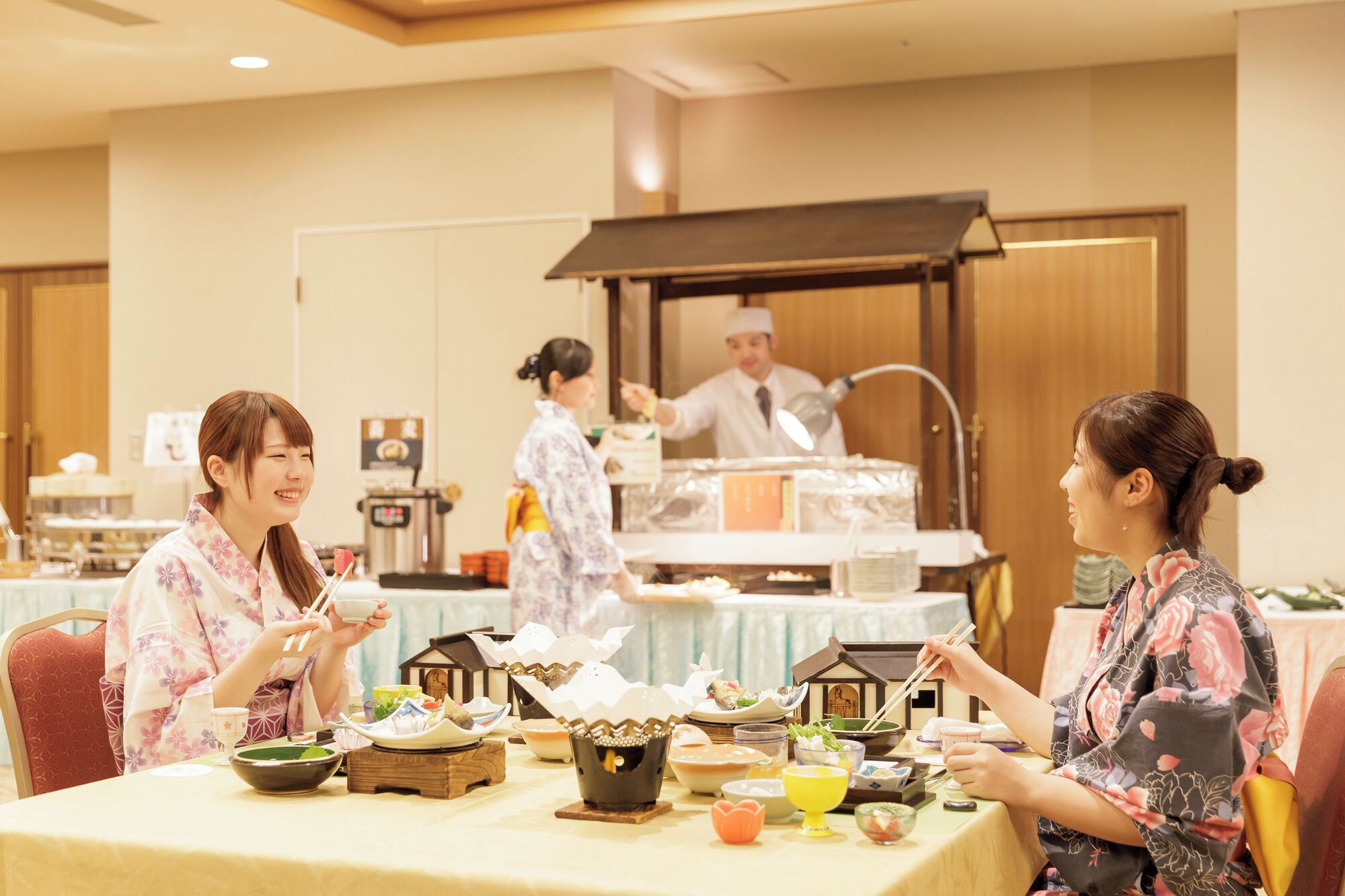 Comedor con mesas dispuestas para una comida, mostrando platos y utensilios tradicionales japoneses.
