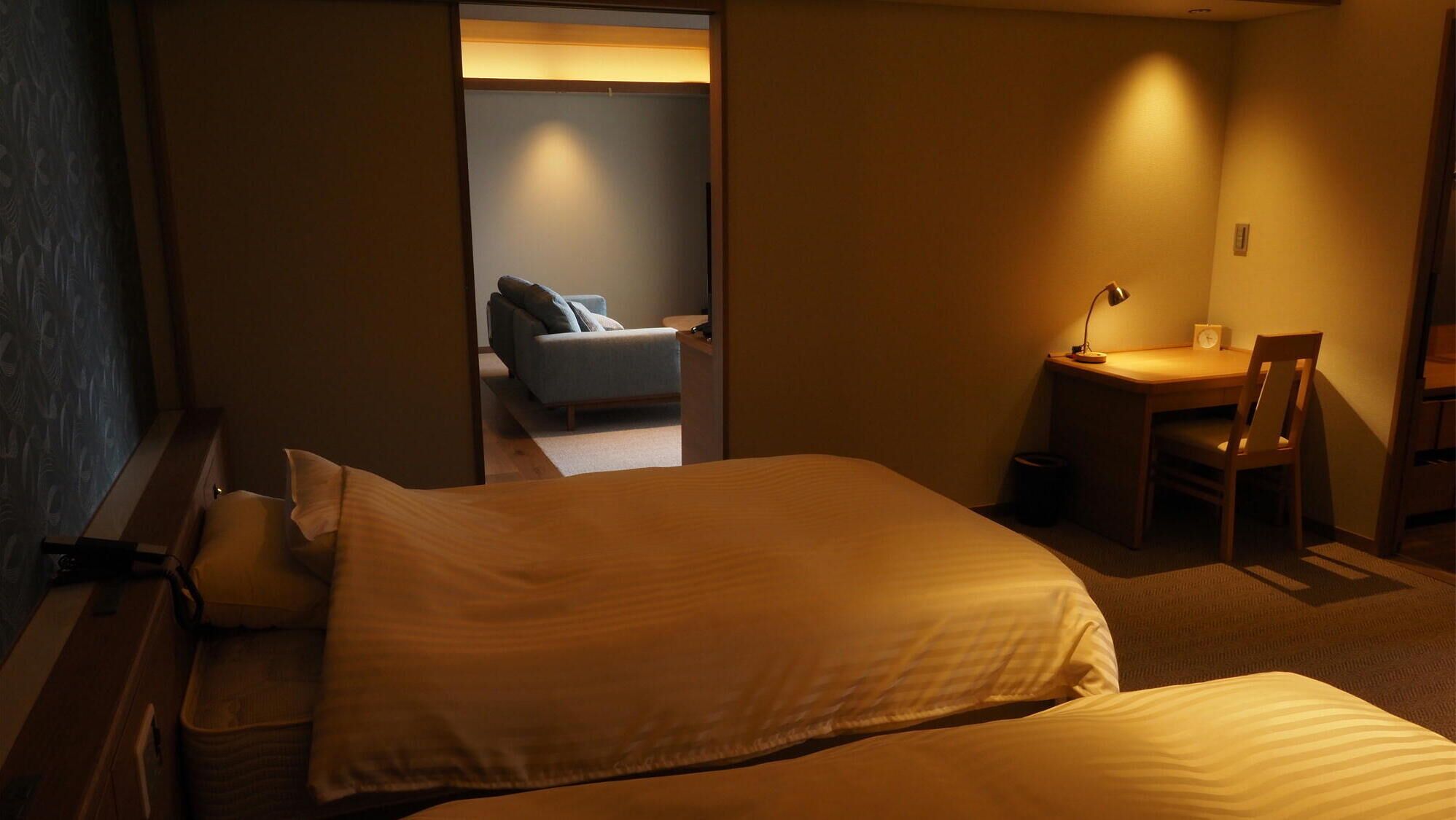 A hotel room with a bed, a desk, and a chair.