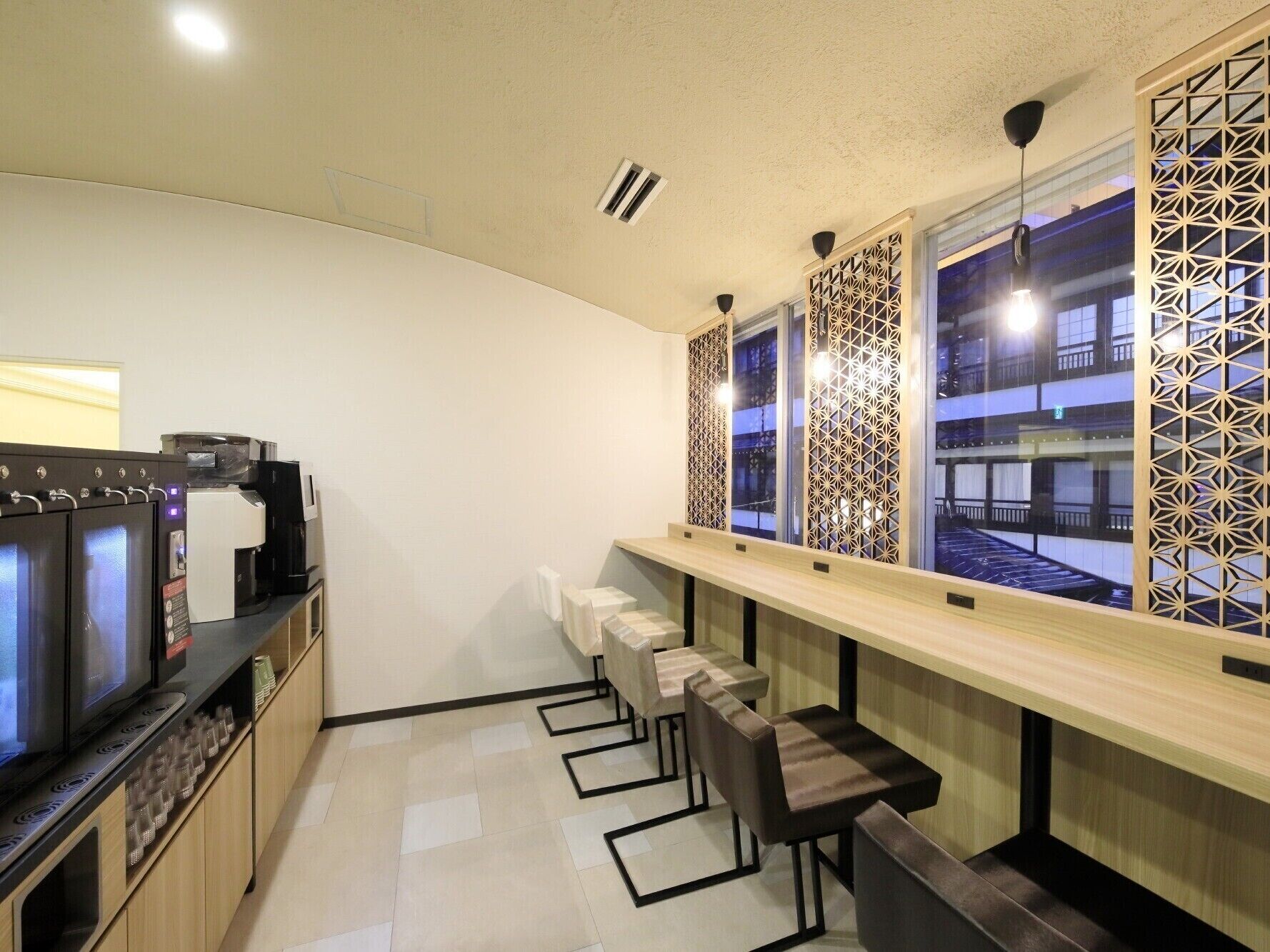 A modern kitchen with built-in appliances, a long counter, and a seating area with bar stools.