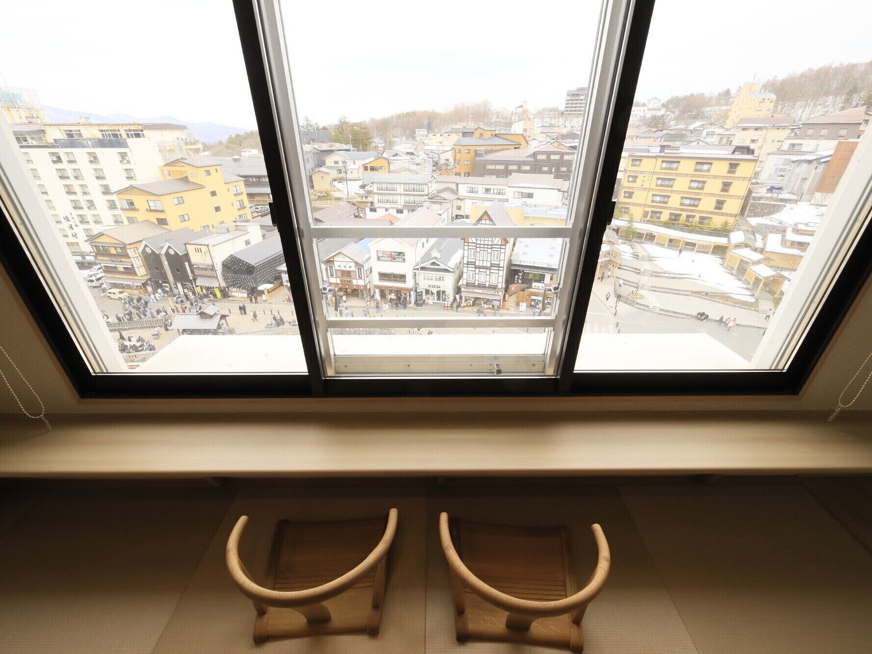 A room with a large window overlooking a cityscape.