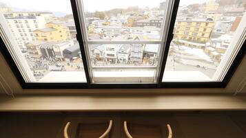 A room with a large window overlooking a cityscape.