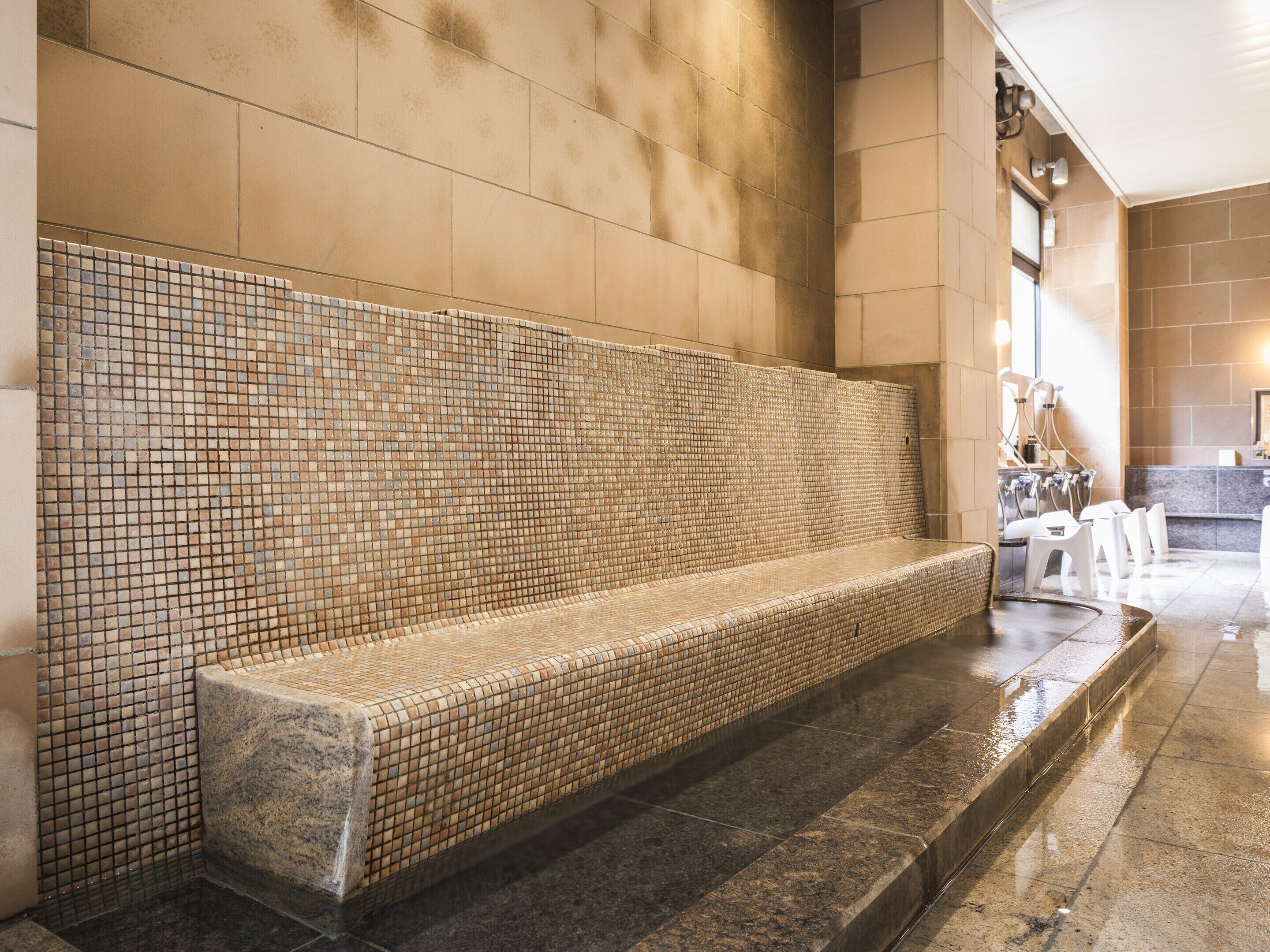 A spa area with a tiled bench, a stone wall, and a reception desk.