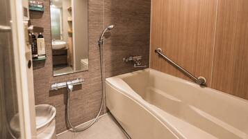 A modern bathroom with a bathtub, a shower, a toilet, and a sink.