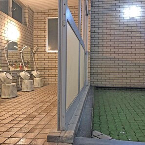 Un bagno con pavimento piastrellato, lavandino con specchio e finestra.