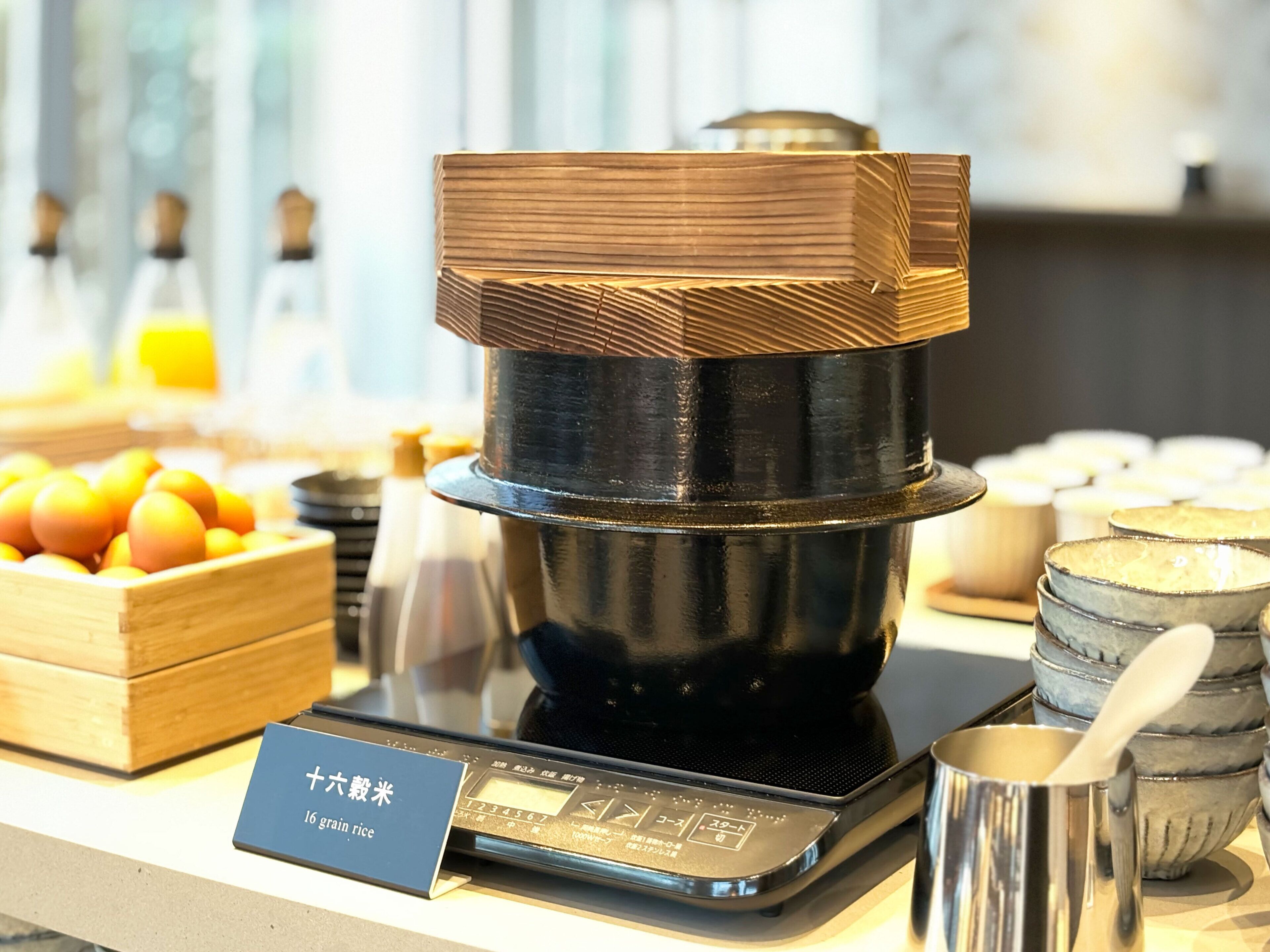 A kitchen counter with a rice cooker, a scale, and a sign indicating '16 grain rice'.