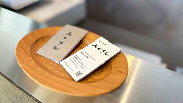 Two business cards on a wooden coaster.
