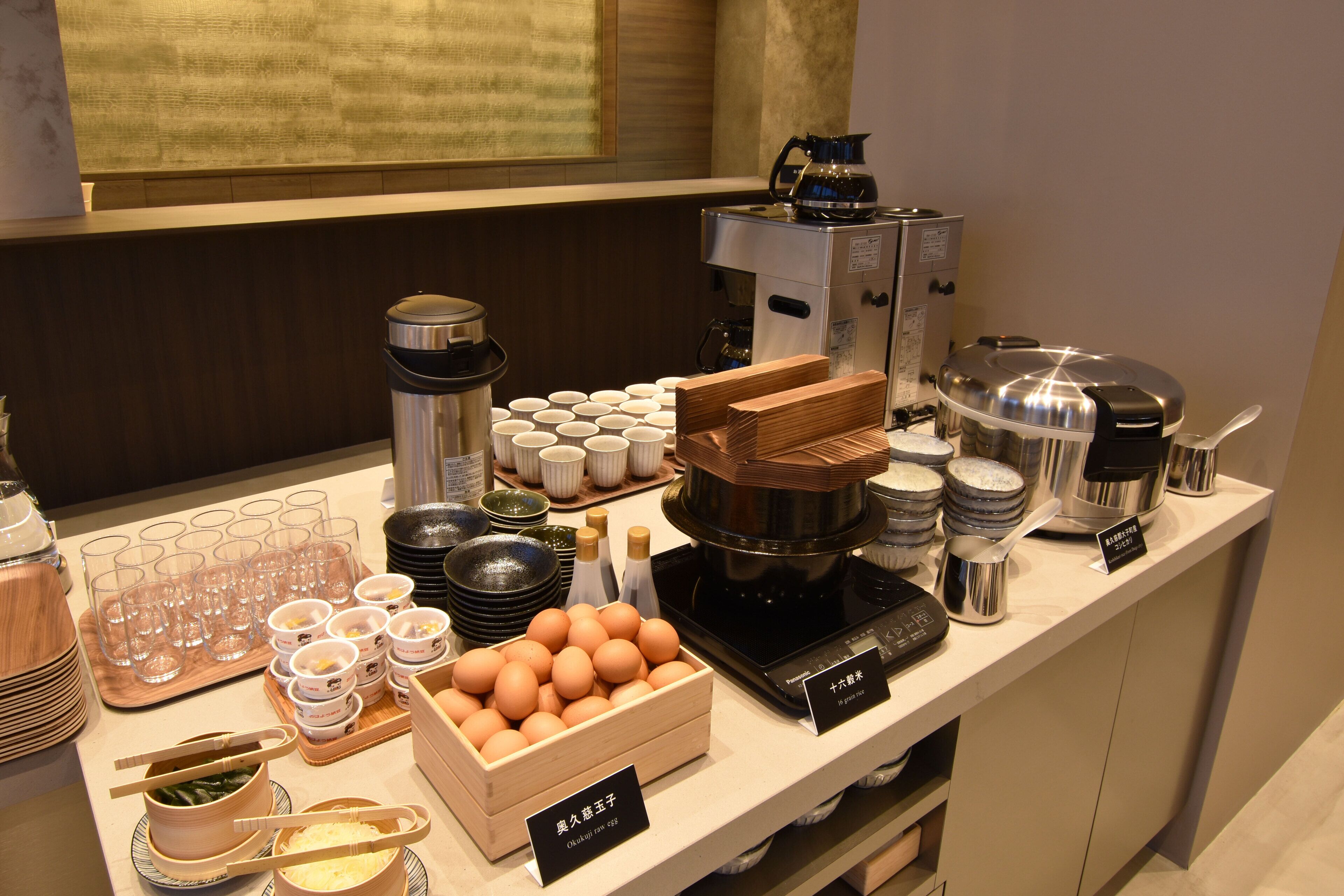 Un buffet proposant une variété de plats et de boissons, notamment des œufs, des saladiers et des machines à café.