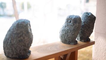 Three stone sculptures on a wooden ledge.