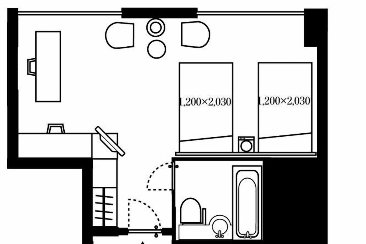 Een plattegrond van een hotelkamer met een bed, een bureau, een stoel, een kledingkast en een badkamer.