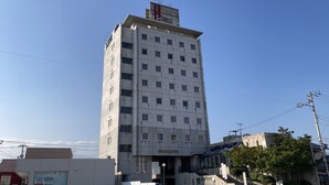 Un edificio alto y rectangular con varias ventanas y un cartel que indica que es un hotel.
