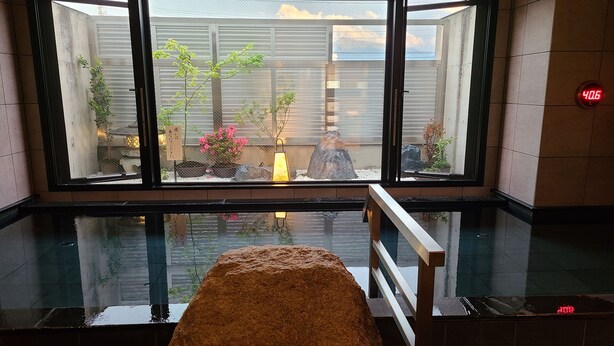 Una habitación con un ventanal grande, una fuente de agua y un banco de piedra.