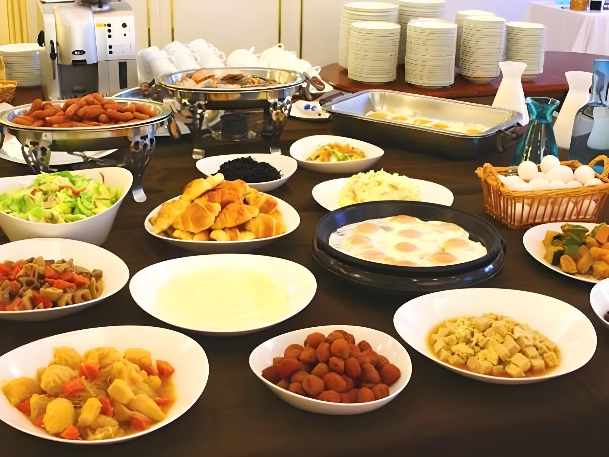 Een buffettafel met diverse gerechten, waaronder salades, vleeswaren en desserts.