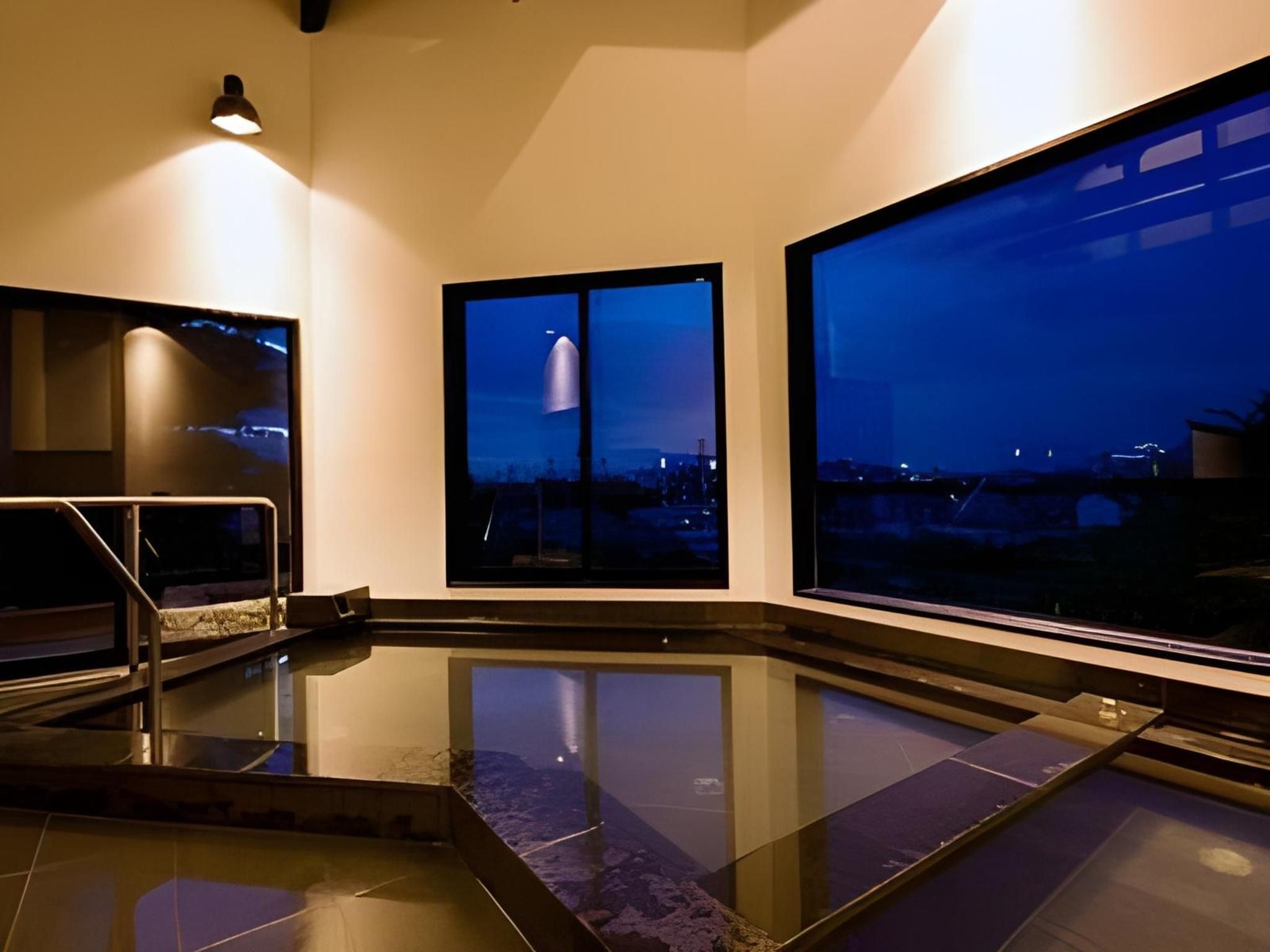 Een modern interieur met een spiegelende vloer, grote ramen en een trap.