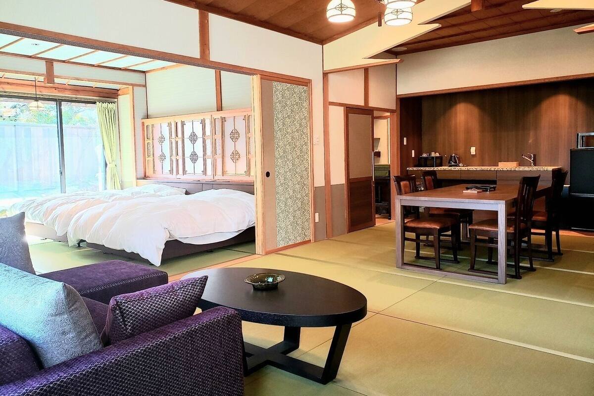 A room with a bed, a dining table, and a sofa.