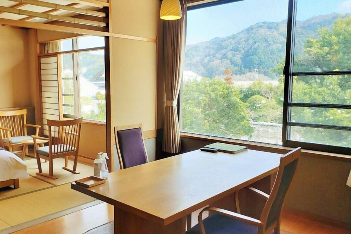 A traditional Japanese-style room with tatami flooring, a low table, and chairs.