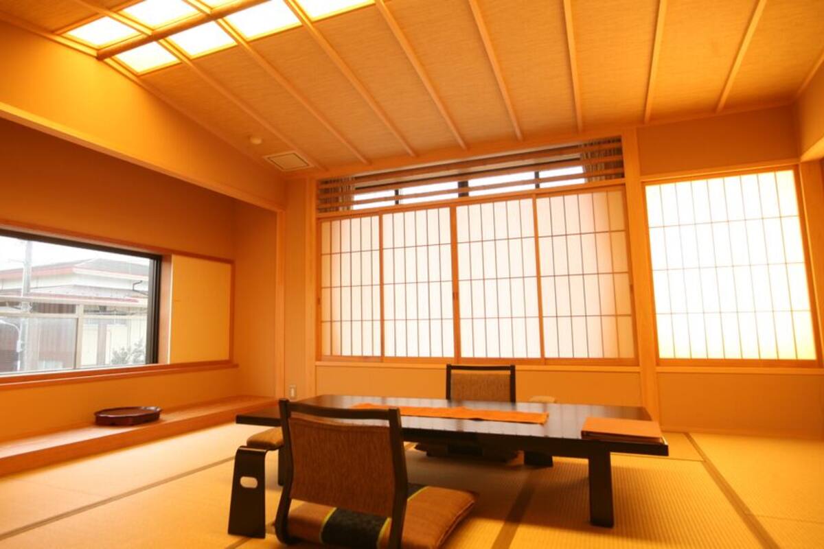 A traditional Japanese room with tatami flooring, a low table, and sliding doors.