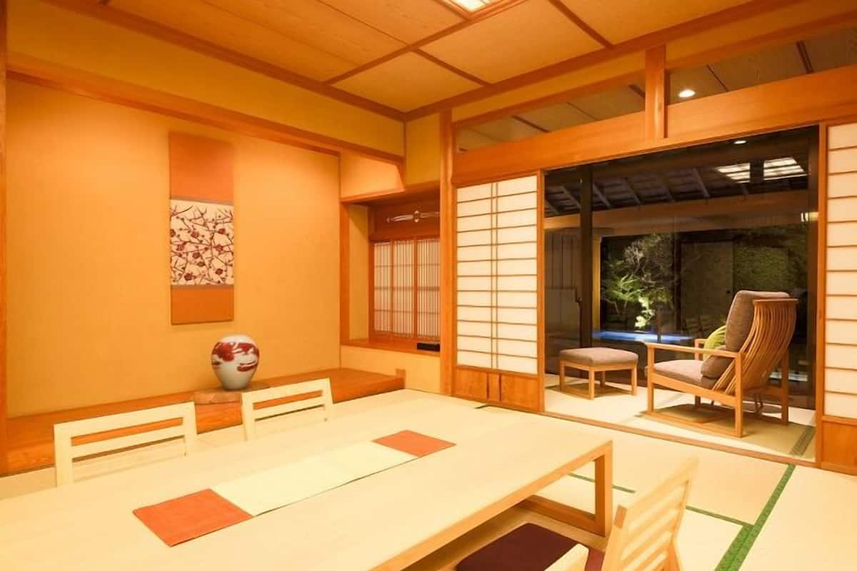 A traditional Japanese room with tatami flooring, a low table, and sliding doors.