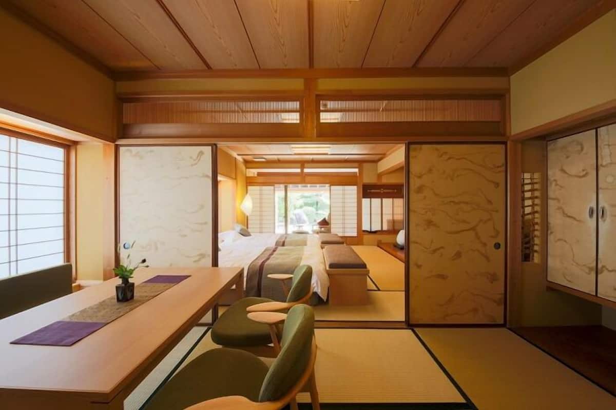 A traditional Japanese room with tatami flooring, a low wooden ceiling, and sliding doors.
