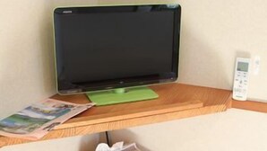 Une pièce comprenant un bureau, un écran d’ordinateur, un clavier, une souris et une petite poubelle.