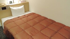 A hotel room with a bed, a bedside table with a lamp, a clock, and a telephone. - Mitsukaido Dai Ichi Hotel (Joso)