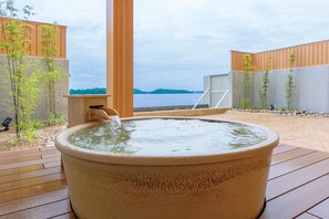 A hot tub on a wooden deck with a view of a body of water and hills in the distance. - Hotel Green Plaza Hamanako (Hamamatsu)