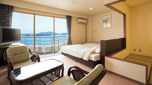 A hotel room with a bed, a TV, a balcony with a view of the sea, and a dining area. - Hotel Green Plaza Hamanako (Hamamatsu)