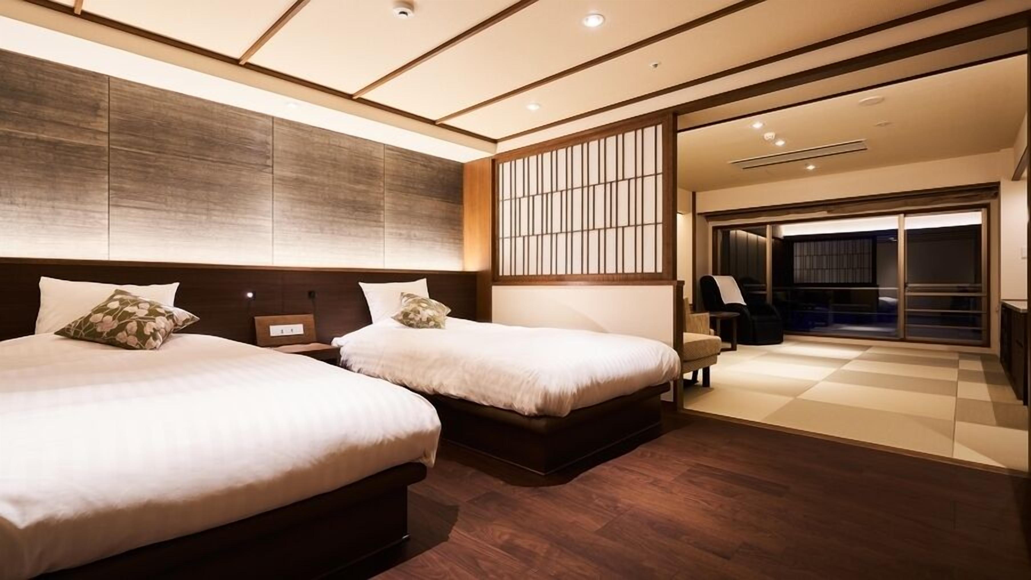 Ett hotellrum med två sängar, ett stort fönster och utsikt över omgivningarna.