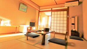 Een traditionele Japanse kamer met tatami vloerbedekking, een lage tafel en een schuifdeur.