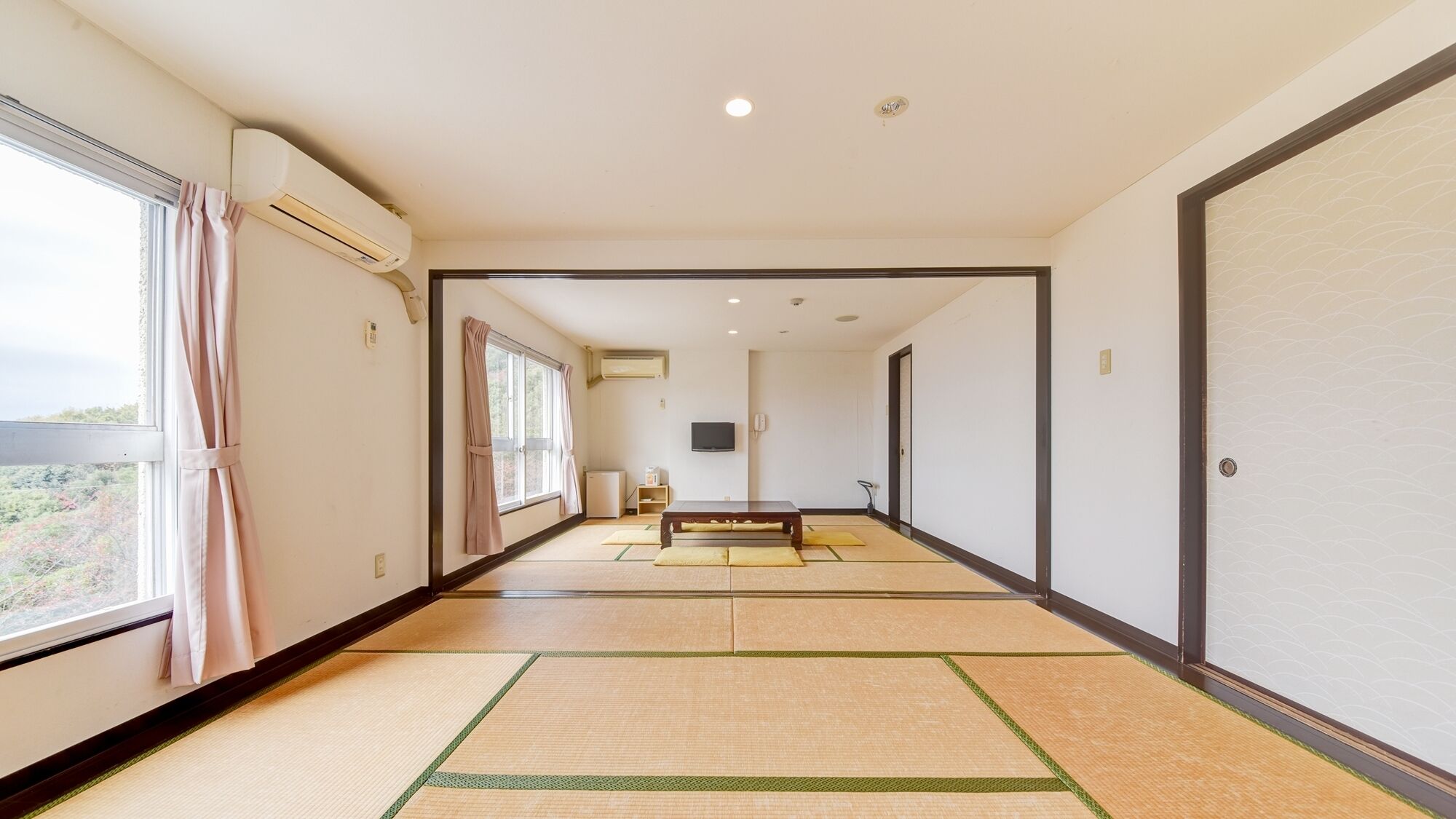 A hallway with tatami mats, a television, and a table.