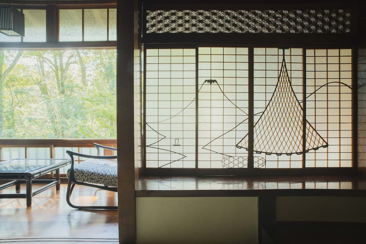 A room with tatami flooring, a low table, and a chair.