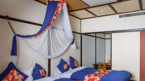A room with a bed, a small table, and a mirror.