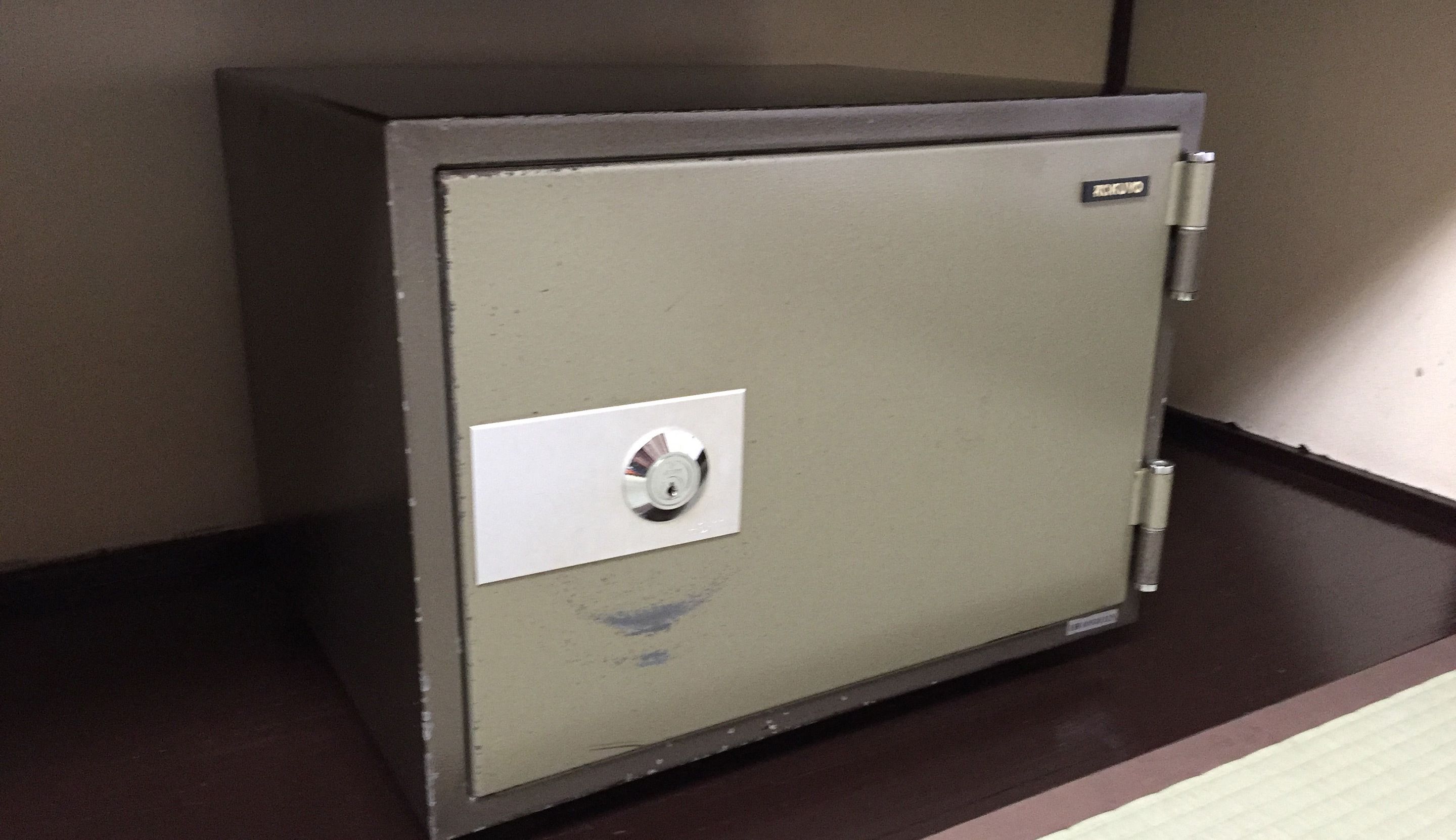 Una caja fuerte de metal con cerradura sobre una superficie oscura.