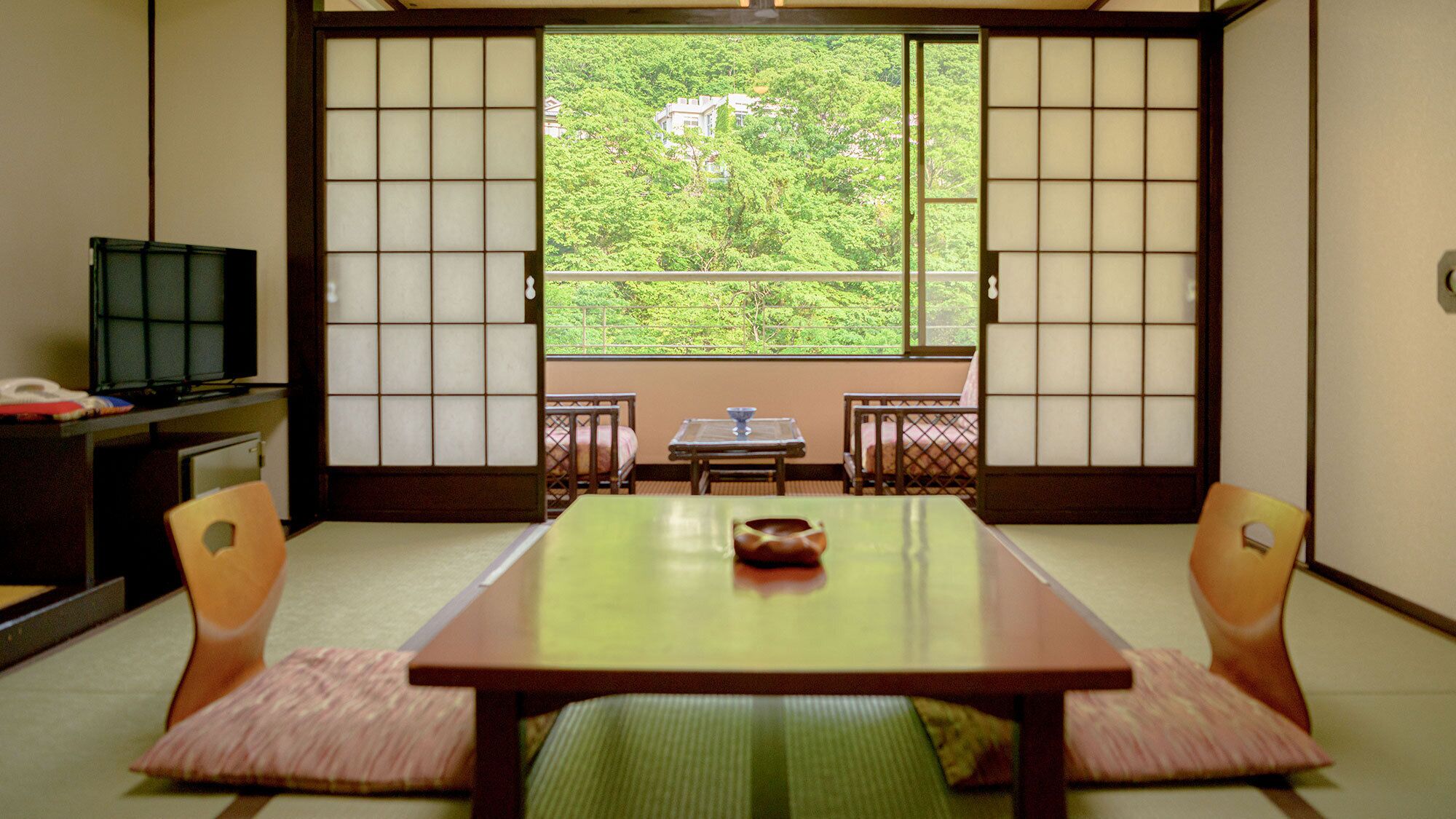 A traditional Japanese room with tatami flooring, a low table, and sliding shoji doors.